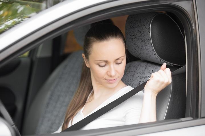 Mujer en automóvil colocándose el cinturón de seguridad
