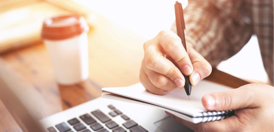 Mano escribiendo en cuaderno Mano escribiendo en cuaderno