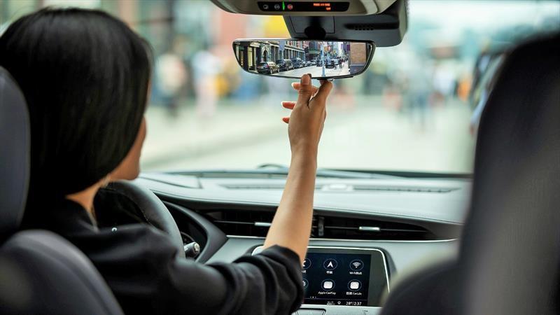 Mujer arreglando el espejo retrovisor Mujer arreglando el espejo retrovisor