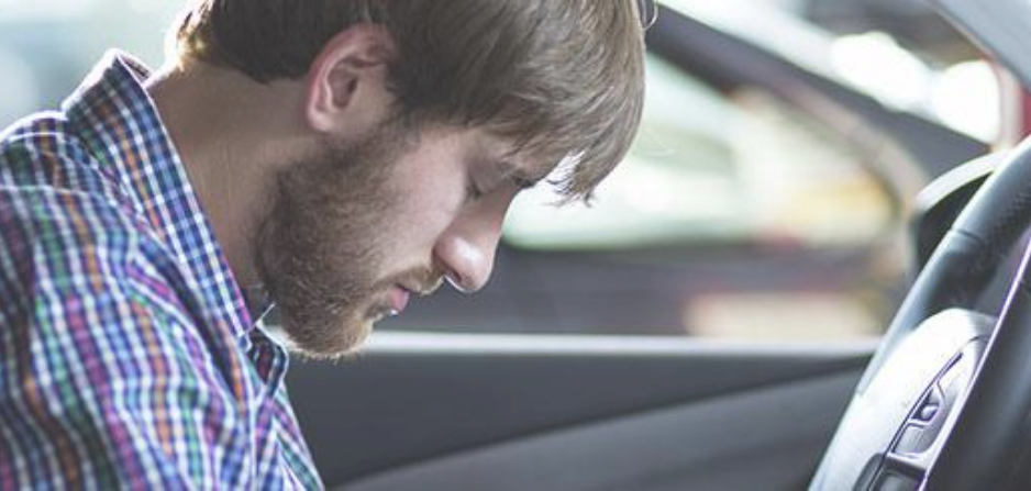Somnolencia al volante Hombre al volante con la cabeza hacia abajo