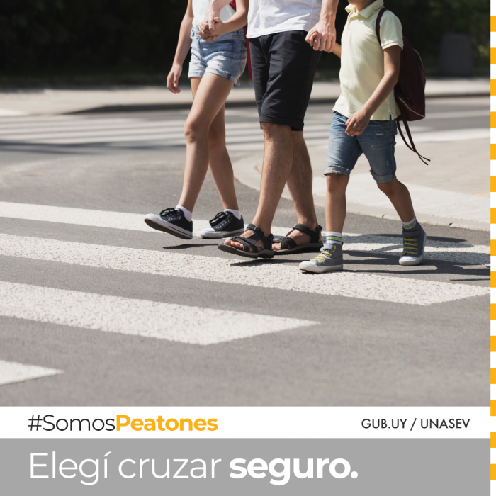 Niños cruzando la calle sobre cebra, frente de auto apenas en el cuadro cediendo el paso.