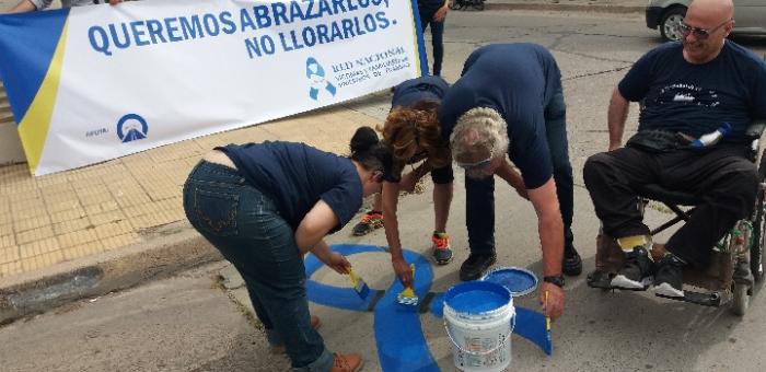 Integrantes de la Red de Víctimas pintando lazo en la calle