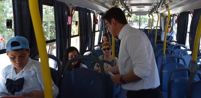 Director de Tránsito riveresnse entregando folletería en un ómnibus