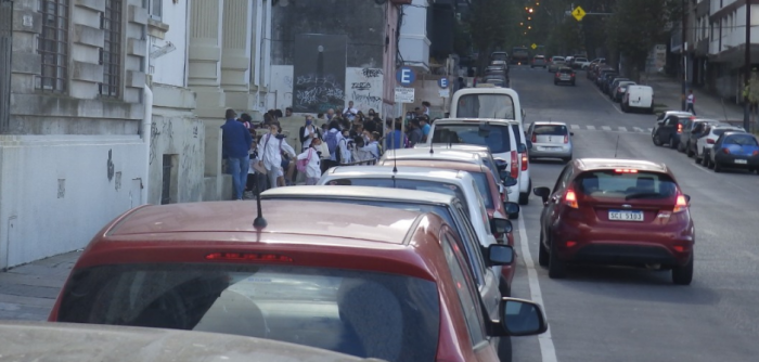 Vehículos estacionados en doble fila frente a local escolar