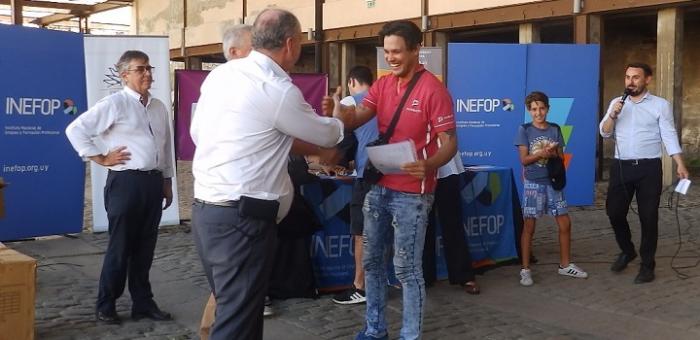 Ministro de Trabajo haciendo entrega de Certificado y Carnet a Repartidor en Moto