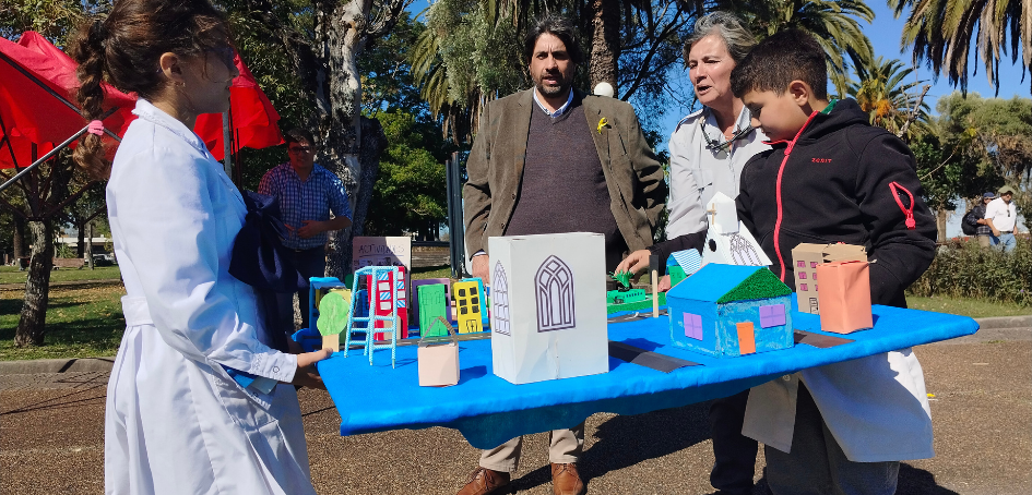 Cecilia Techera junto a Marcelo Metediera ayudando a trasladar maqueta a escolares de Young