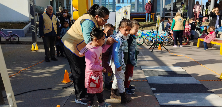 Integrante del Club de Leones de Tacuarembó con niña en bicicleta
