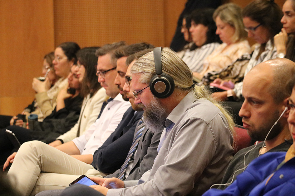 Personas en sala escuchando los paneles