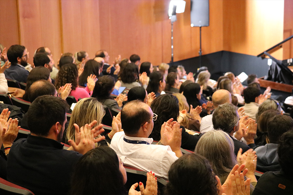 Personas de espalda mirando hacia el escenario