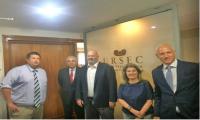 El presidente de Ursec junto a los otros dos directores y los ejecutivos de Facebook Presidente y directores de Ursec parados junto a los visitantes detrás de un vidrio que dice Ursec